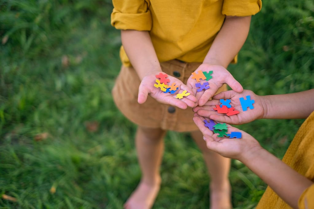 Children hold pieces of puzzles in palms as sign of support and solidarity with people with autism