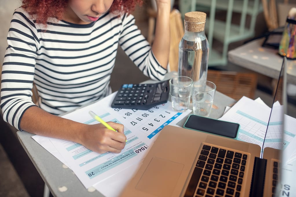 Businesswoman calculating her profits and filling tax declaration