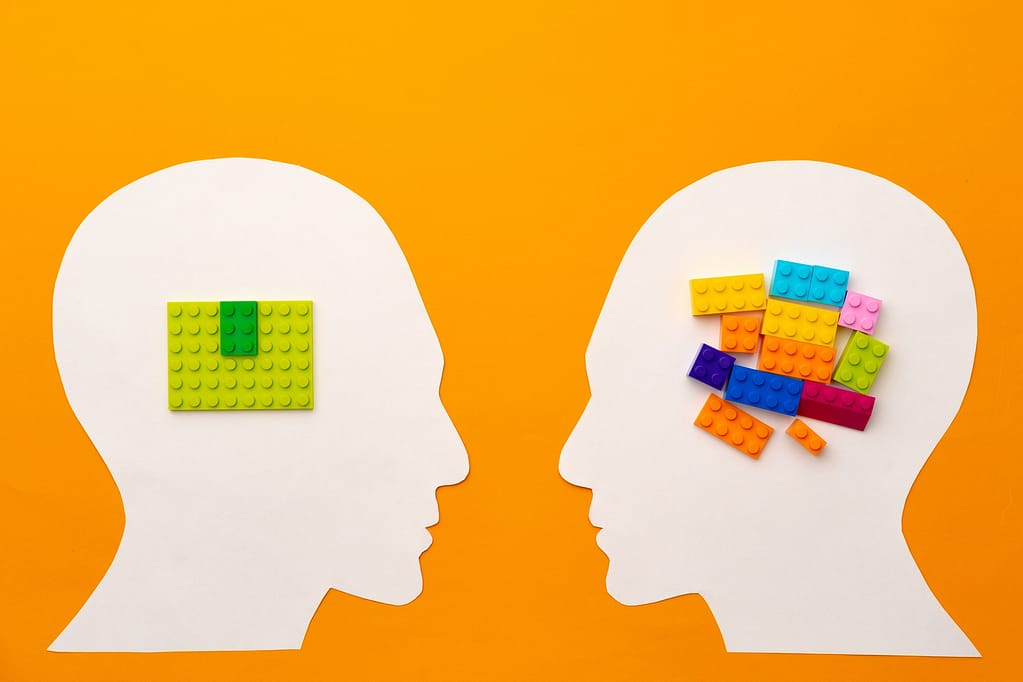 Papercut head silhouette with toy constructor pieces on yellow background