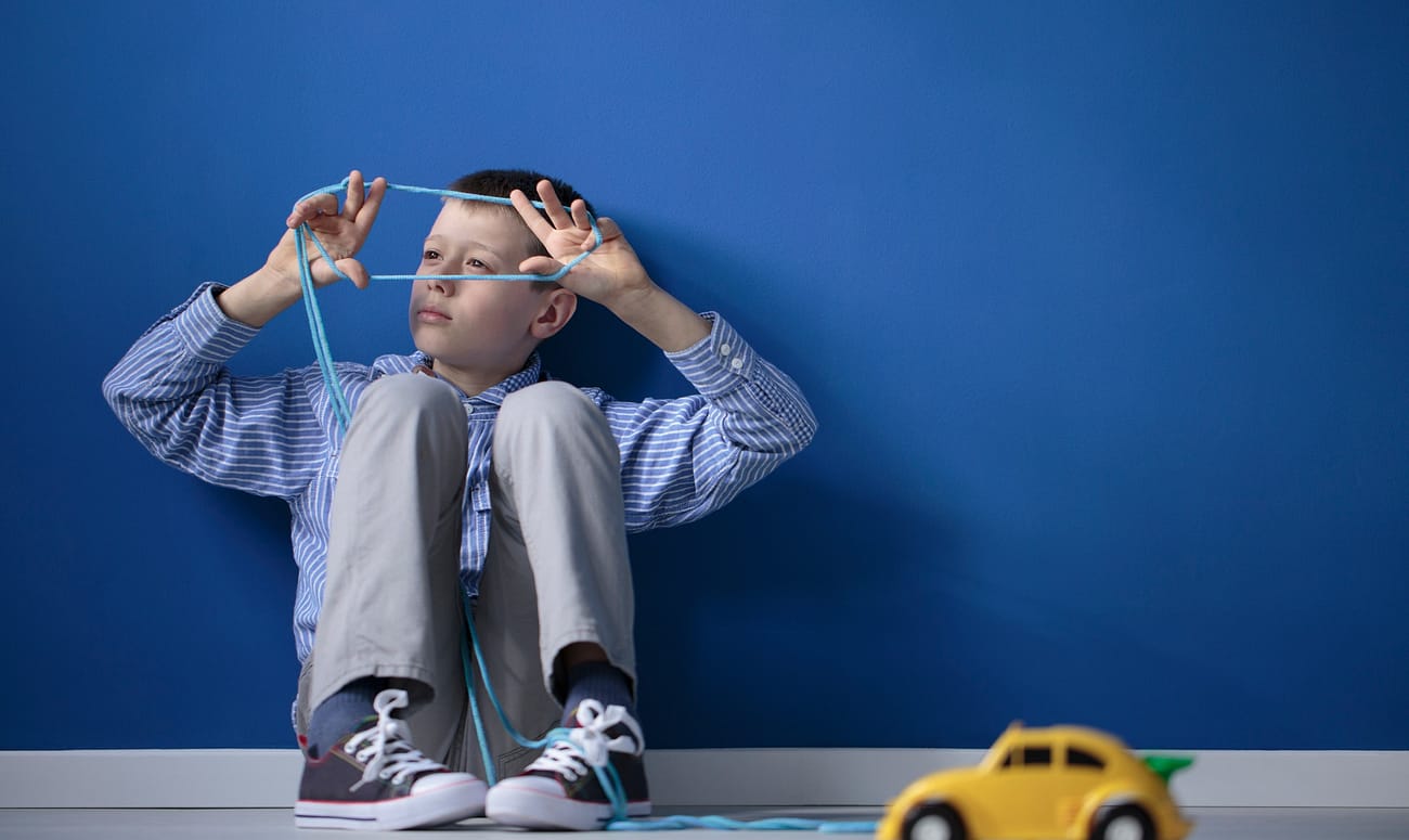 Autistic child playing with string