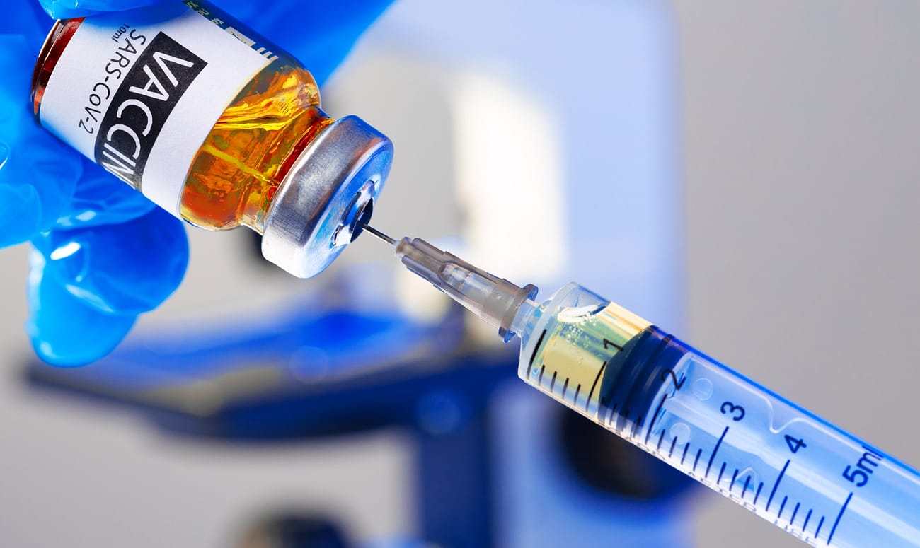 Covid-19 vaccine bottle with a syringe taking the vaccine from it